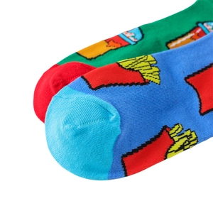 Macro shot of knitted cotton socks with pixelated burger and fries cartoon patterns