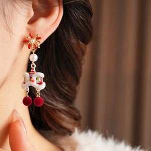 Detailed view of Chinese Lion Dance earrings with red velvet balls and pearl accents