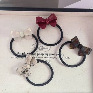 Set of four handmade acetate bow hair ties in burgundy, pearl, and amber marble patterns