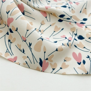 Macro detail of floral pattern fabric with pink hearts and cream white texture