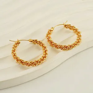 Gold plated titanium steel twisted hoop earrings displayed on a white textured tray