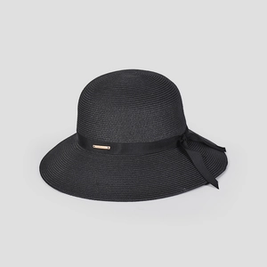 Detail of black woven straw hat with satin ribbon bow and gold logo plaque detail