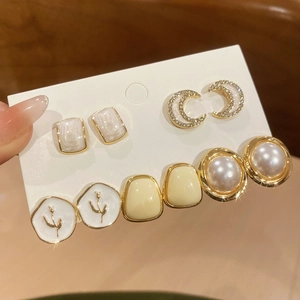 Dettaglio ravvicinato di un set di 5 paia di orecchini vintage con fiori e perle
