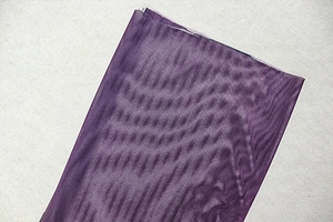 Dettaglio del tessuto a rete viola traspirante che mostra una struttura a maglia fine
