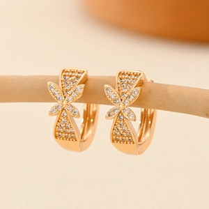 Detailopname van champagne gouden oorringen met zirkonia pavé op een houten rek