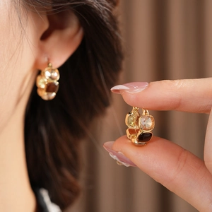 Detail of vintage gold hoop earrings with square amber and clear crystal inlay