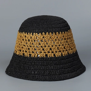 Detail of hand-woven straw bucket hat with black and brown hollow-out breathable patterns