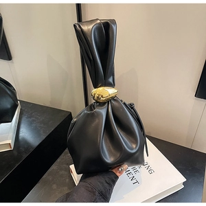 Detail of black pleated cloud bag featuring a unique irregular gold metal buckle handle