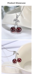 Macro detail of S925 silver cherry pendant with red stones and leafy silver decoration