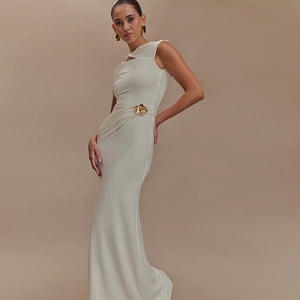 Detail of elegant white satin dress featuring a golden flower metal waist ornament