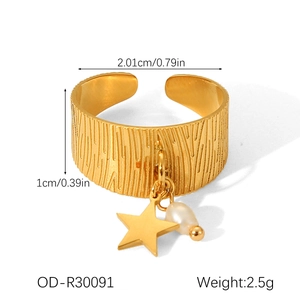 Detailed view of adjustable golden star ring with bark texture and hanging pearl