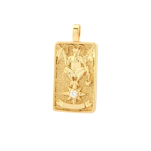 Close-up of golden tarot square pendant with winged figure and cubic zirconia inlay