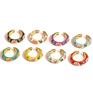 Detailed flat lay of eight colorful enamel flower open rings in vibrant assorted colors