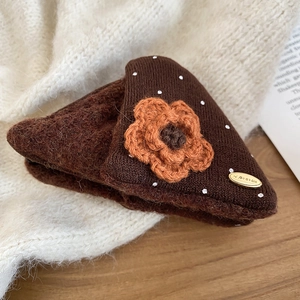 Detail of plush triangle hair claw with orange crochet flower and white polka dots