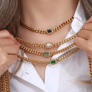 Detail of Cuban chain necklaces with rectangular gemstones in multiple colors on a model