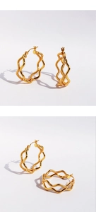 Close-up of golden double-layer wave hoop earrings with textured metallic finish