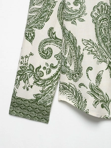 Detail of paisley print on green cotton-linen fabric showing cuff and hem texture