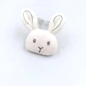 Gros plan d'un accessoire lapin en peluche blanche avec broderie, 6,5cm x 5cm