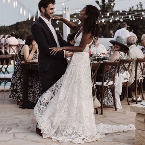 Elegante abito da sposa in pizzo bianco con scollo a V profondo e lungo strascico regale