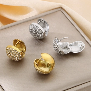 Macro detail of gold and silver dome earrings with pavé set sparkling zircons