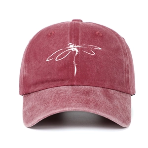 Detail of dragonfly print on burgundy washed denim baseball cap with curved brim