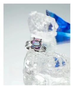 Macro shot of silver star ring with gradient zircon on crystal ice background