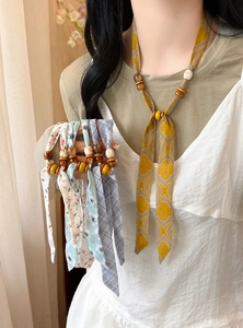 Detail of printed chiffon necklaces with wooden and acrylic beads in various patterns.