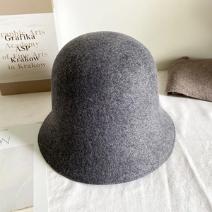 Gros plan sur la texture en feutre de laine gris foncé et les détails du chapeau cloche