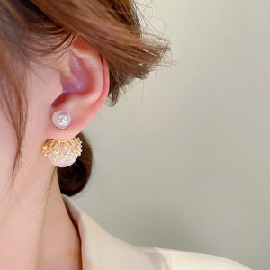 Elegant gold crown pearl drop earrings with crystal studs worn by a female model