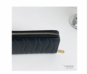 Close-up of black PU leather long wallet with wave quilting and gold metal zipper