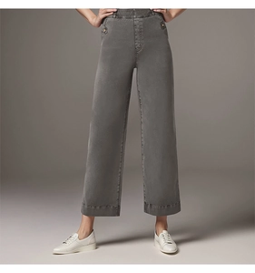 Detail of high-waist wide-leg trousers in dark gray with button waist and smooth texture