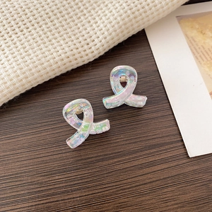 Close-up of iridescent mini butterfly hair claws on a warm wooden background