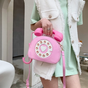 Pink retro telephone shaped crossbody bag in patent leather finish with creative handle