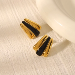 Detailed macro of 18k gold earrings featuring black enamel and radial texture design