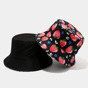 Detail of reversible bucket hats in solid black and vibrant strawberry fruit pattern print