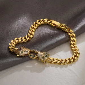 Iced out leopard head Cuban chain bracelet in gold finish with sparkling green gemstone eyes