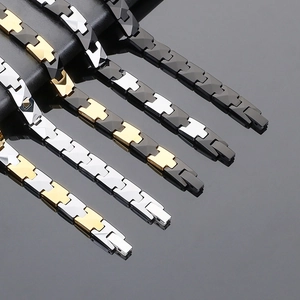 Detailed H-link tungsten steel bracelets in various color combinations on a leather stand
