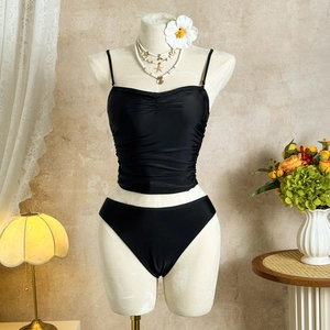Detail of black two-piece bikini featuring elegant ruched texture and slim shoulder straps