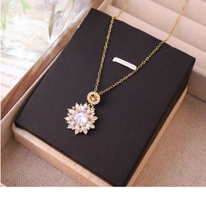 Close-up of luxury sunflower pendant necklace featuring 18K gold chain and zircon stones
