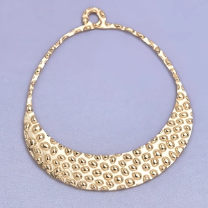 Detailed close-up of golden crescent pendant featuring unique hammered texture finish