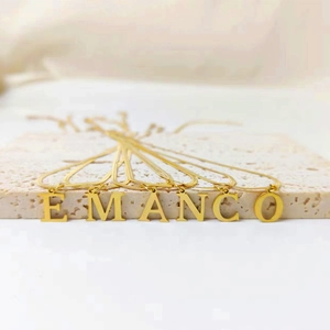 Detailed shot of eManco gold stainless steel necklaces with letters on snake chains.