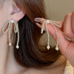 Eleganti orecchini a fiocco in cristallo con perle bianche e nappe pendenti