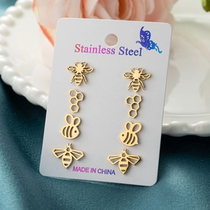 Set of 4 gold stainless steel bee and honeycomb stud earrings on a card display