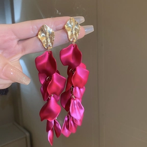 Close-up of long rose red petal tassel earrings with textured gold metallic leaf studs
