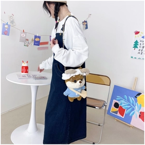 Detail of cute brown plush dog crossbody bag with blue sweater and gold chain strap