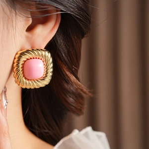 Nahaufnahme von Vintage Gold-Ohrringen in Quadratform mit rosa Schmuckstein in der Mitte