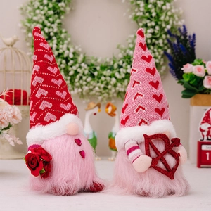 Close-up of Valentine gnomes with knitted heart hats holding a rose and love bow