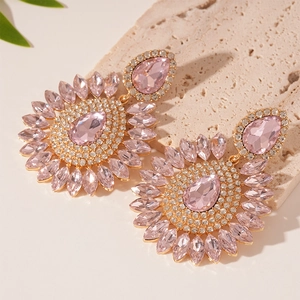 Detailed close-up of luxury water-drop flower earrings with pink crystals and gold finish