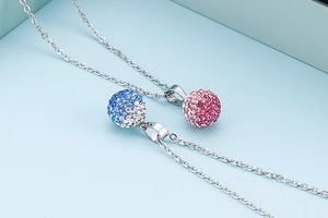 Detailed view of silver O-chain necklaces with sparkling blue and pink crystal ball pendants