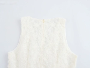 Close-up of intricate floral lace pattern and hidden back zipper on white sleeveless top